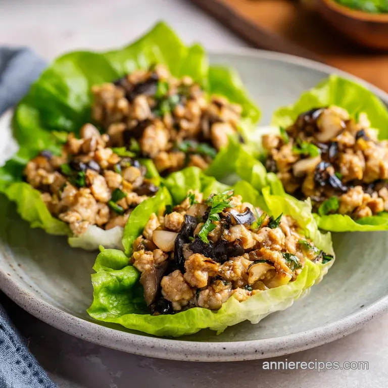 A platter of crisp emerald lettuce cups filled with seasoned meat, arranged neatly beside a small bowl of dipping sauce.