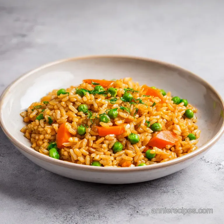 A neat mound of glistening fried rice topped with sliced scallions, served on a clean white plate with chopsticks.